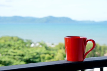 Obraz premium Red coffee mug relax in the morning with sea view background