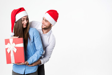 Man and woman smiling and holding presents on a white background.