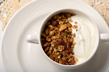 Healthy breakfast: Greek yogurt with homemade granola in a white bowl