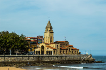 Fototapeta na wymiar Landscape of San Lorenzo beach and San Pedro church in Gijon, Asturias, Spain.