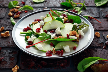 Homemade Autumn Apple Cranberry Salad with walnut, feta cheese and vegetables