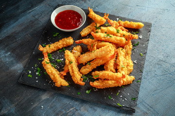 Fried Shrimps tempura with sweet chili sauce on black board stone