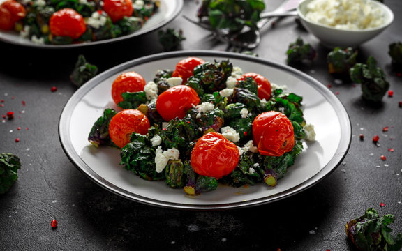 Homemade Roasted Green Kalettes salad with cherry tomatoes and feta cheese. healthy food