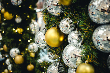 Golden & Silver color of christmas ball on the branches fir with beautiful light bokeh, Decorated Christmas tree. New Year Decoration festive background with vintage tone and selective focus.