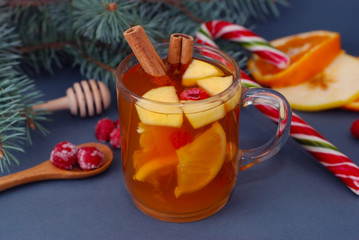 Hot Winter Fruit Tea in a Glass Cup , Cinnamon Stick, Orange and Tangerine, and Fir branch.