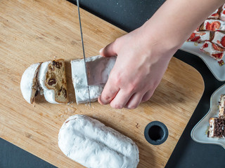 Overhead View Female Hands Cut German Marzipan Stollen With Knife On Wooden Board
