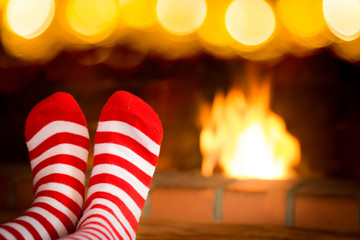 Child in Christmas socks near fireplace