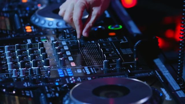 DJ plays mix on controller at a disco in the nightclub
