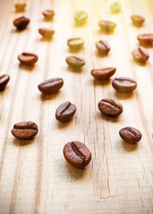 Grains of coffee scattered on a wooden table.
