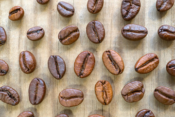 Grains of coffee scattered on a wooden table.