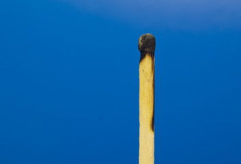Burned match on a blue background