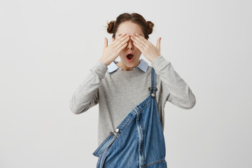 Female hipster covering eyes with hands emotionally reacting on congratulations. Good-looking woman...