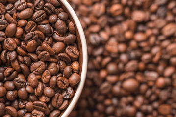Ceramic cup filled with coffee beans close up. Beverages menu design. Place for text.