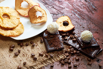Dried fruits, apple, bananas, coffee and chocolate for breakfast