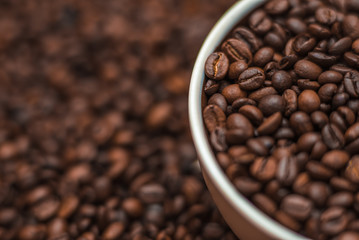 Ceramic cup filled with coffee beans close up. Beverages menu design. Place for text.