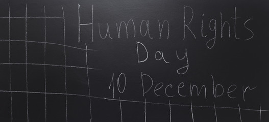 Human rights concept: The text: Human rights day written on blackboard.