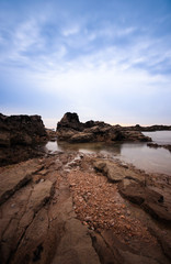 Long exposure in amazing Wild rock beach at the sunset. Sintra Cascais Natural park