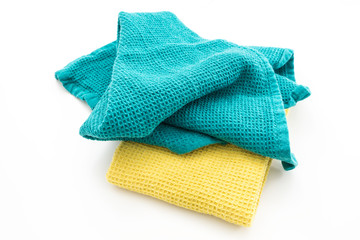 Messy and folded colorful kitchen towels, on white background.