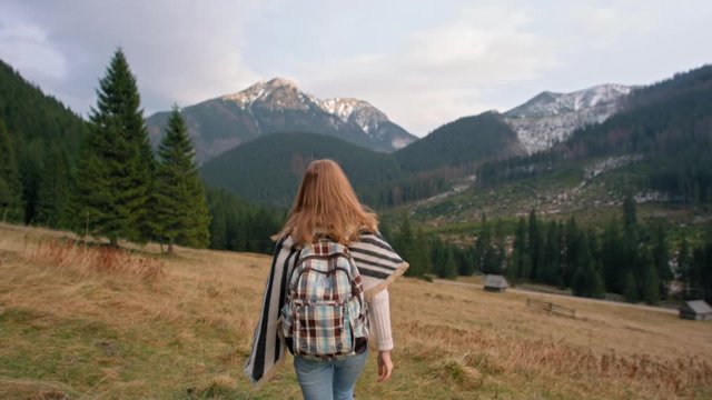 Happy Young Woman is Rising Hands as a Winner Reaching Goal and Cheering Victory in Amazing Mountains in Slow Motion