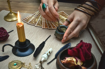Woman witch prepare a magic potion. Future reading. Tarot cards on fortune teller desk table.