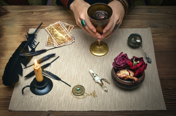 Woman witch prepare a magic potion. Future reading. Tarot cards on fortune teller desk table.