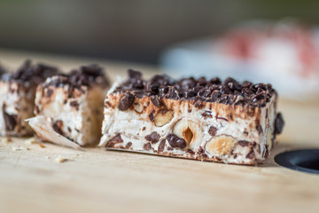 CLoseup Chocolate and Nut Nougat with Knife on Wooden Board