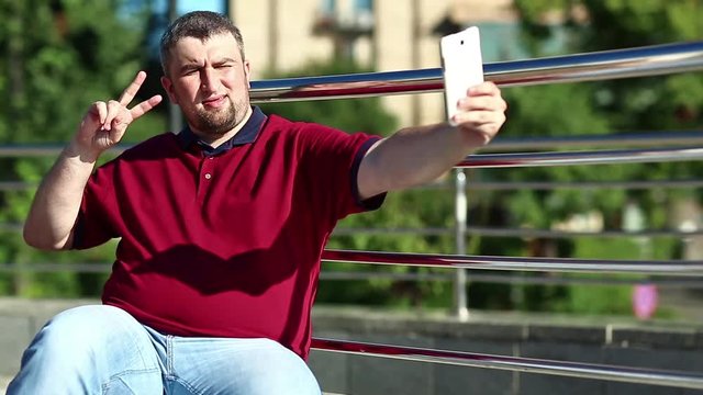 Man makes selfie. Man makes photos on his smartphone