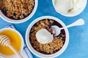 Winter breakfast with berry crumble dessert and tea with lemon.