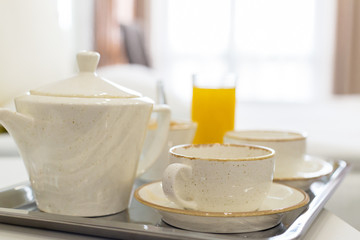 Two white mugs on a tray white bed, breakfast concept
