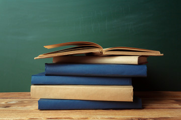 Classroom with blackboard, wooden table and books