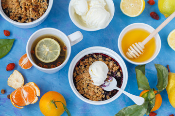 Winter breakfast with berry crumble cake and tea with lemon.