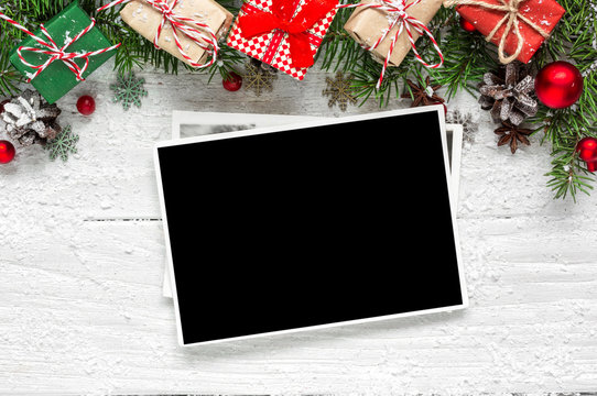 christmas blank photo frame with fir tree branches, decorations and gift boxes