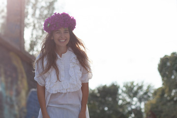 smiling hipster girl with flower wreath on head 