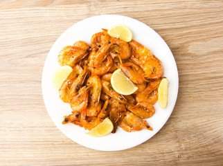 Fried shrimps with lemon. Shrimp fried in a frying pan with butter and garlic.