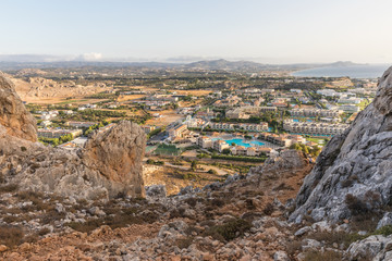 Fototapeta na wymiar Stony landscape of Tsambika mountain and a view of Kolymbia in the early morning, a small resort on the Rhodes Island, Greece. 