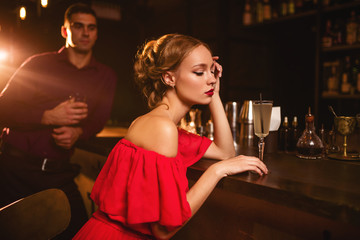 Woman in dress and man behind bar counter, flirt