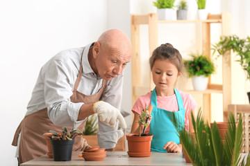 Senior man gardening with his granddaughter at home