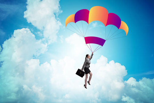 Businesswoman flying on parachute in business concept