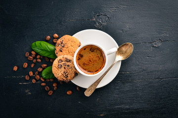 Coffee and oatmeal chocolate cookies on a wooden background. Coffee beans. Top view. Free space for text.