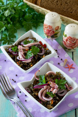 Homemade snacks on the festive table. Salad with octopus and sea cabbage.