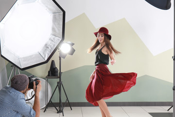 Beautiful young model posing for professional photographer in studio
