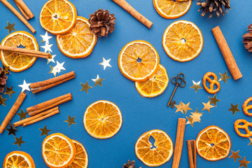 Dried orange slices and cinnamon on blue background