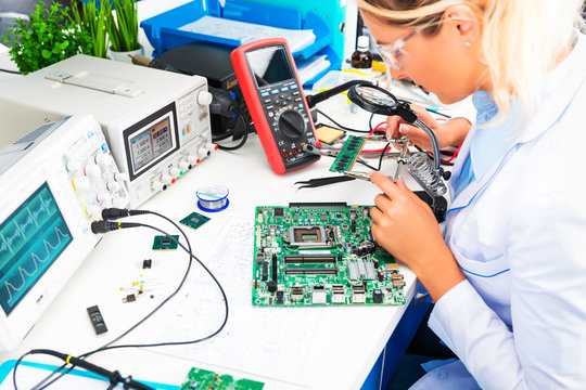 Female electronic engineer checking circuit board in laboratory