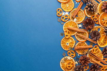 Dried orange slices and cinnamon on blue background. Space for text