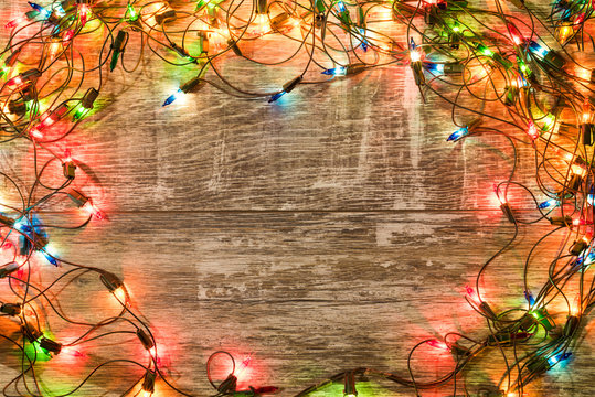 Christmas holiday background. Christmas lights lie on dark, old boards. New Year background. Christmas decorations. Xmax background. Christmas tree.