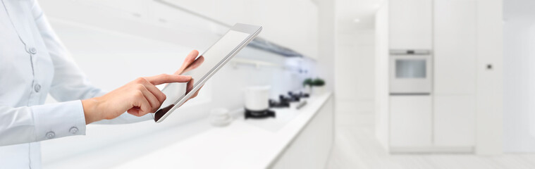 hands touch the digital tablet on kitchen background smart home automation web banner and copy...