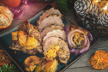 Roulade of duck breast fillets stuffed with Mandarin oranges, red onions and grilled mandarins on the Christmas table.