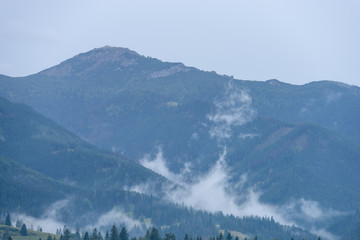 Fototapeta na wymiar mountain tops in autumn covered in mist or clouds