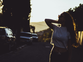 silhouette of beautiful woman standing on the road  during summer sunset