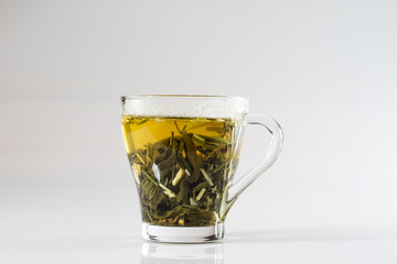 Tea in a glass on a white background. Green or fruit tea.